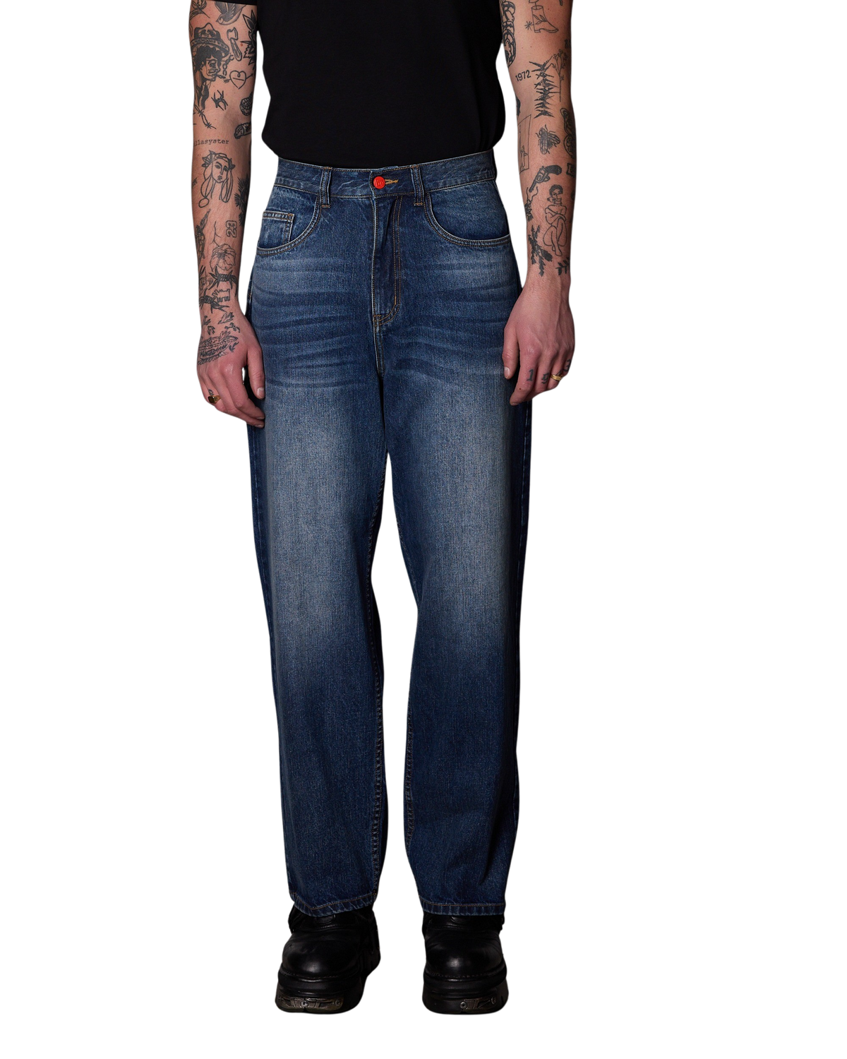 A person wearing BeWider Super Loose in Blue Dream denim jeans with whiskering and subtle fading, paired with a black shirt and black boots, shown against a plain white background.