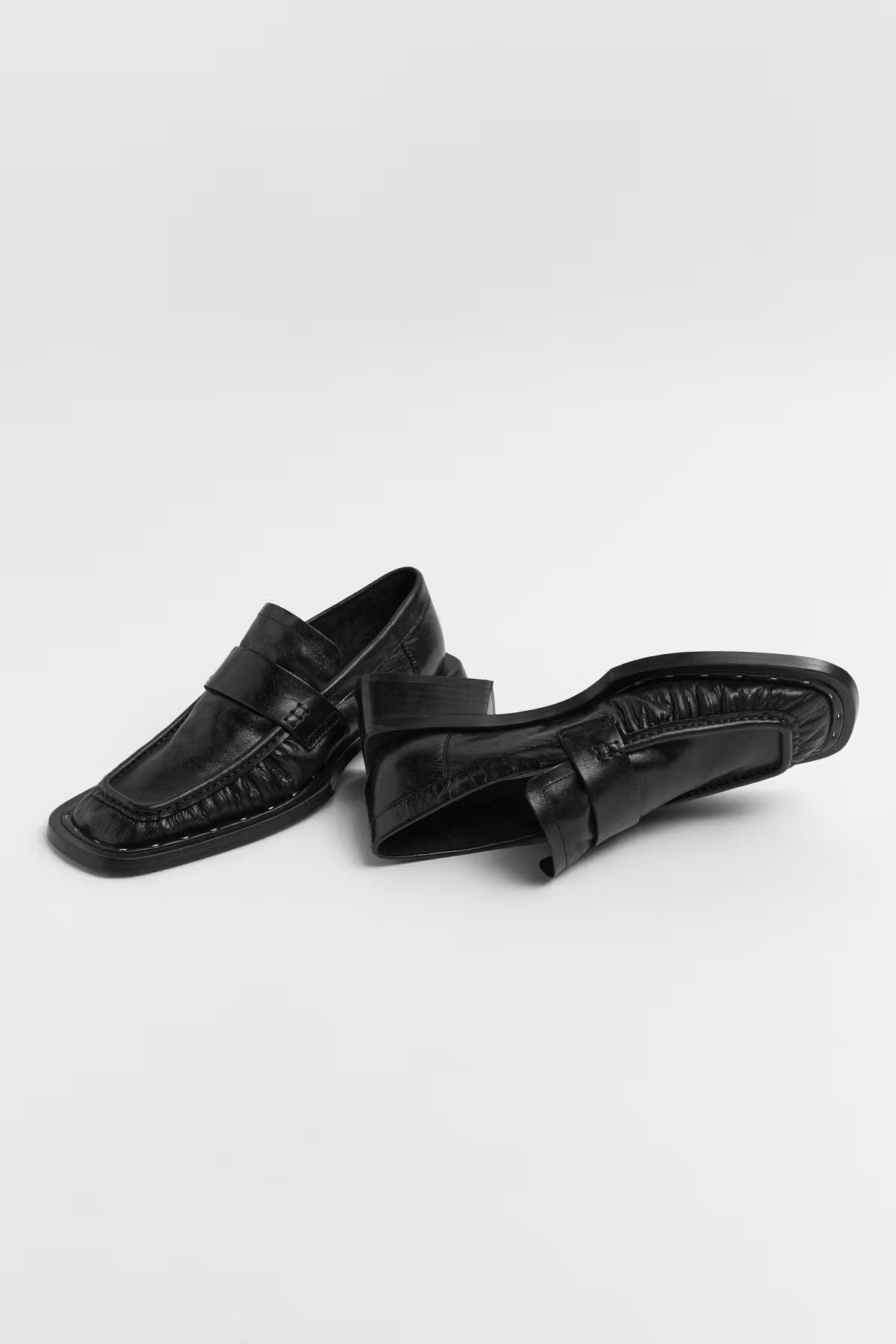 Pair of black Miista Airi loafers on a white background