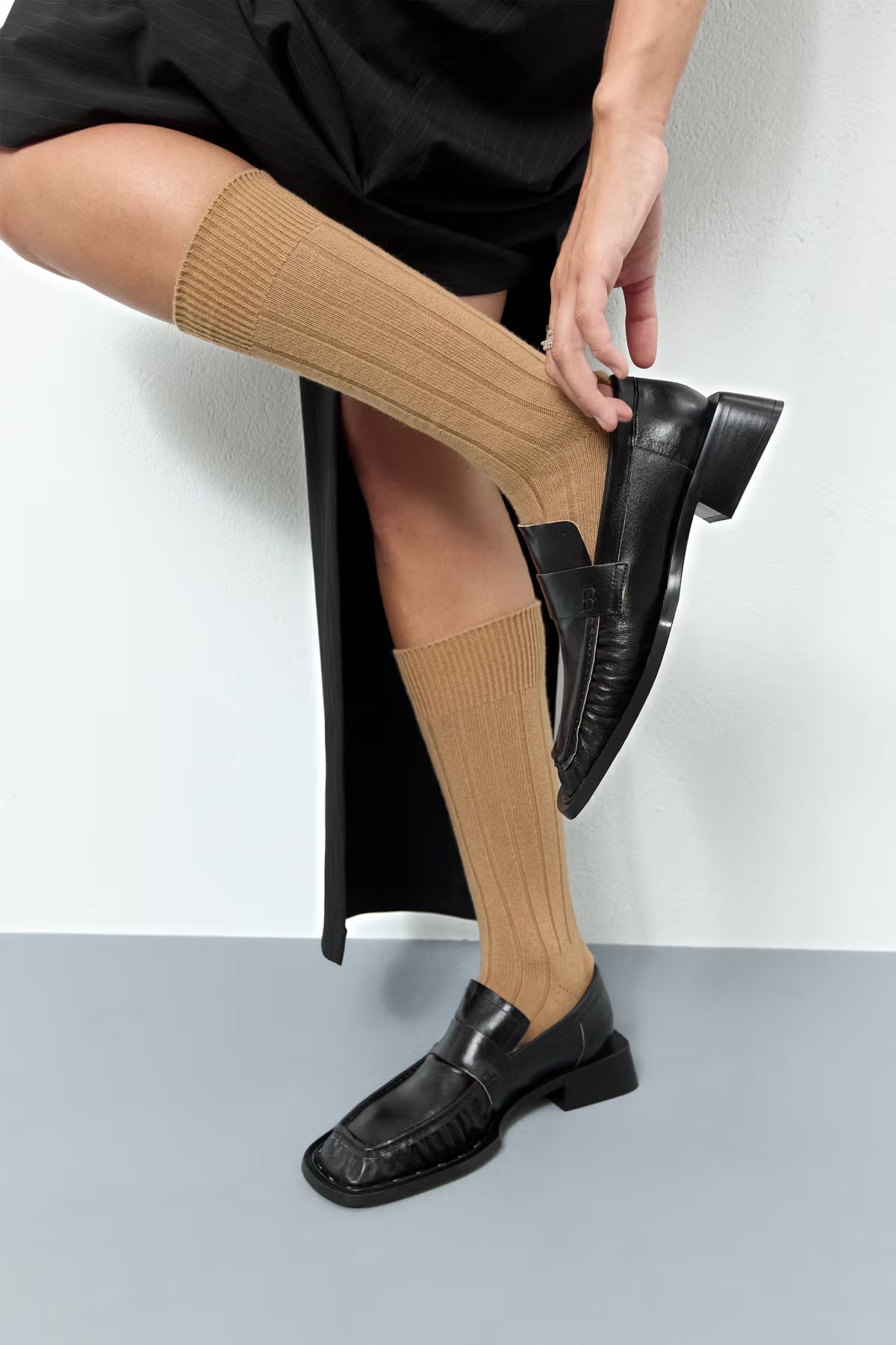 Black Airi loafers side view with model putting her foot into it